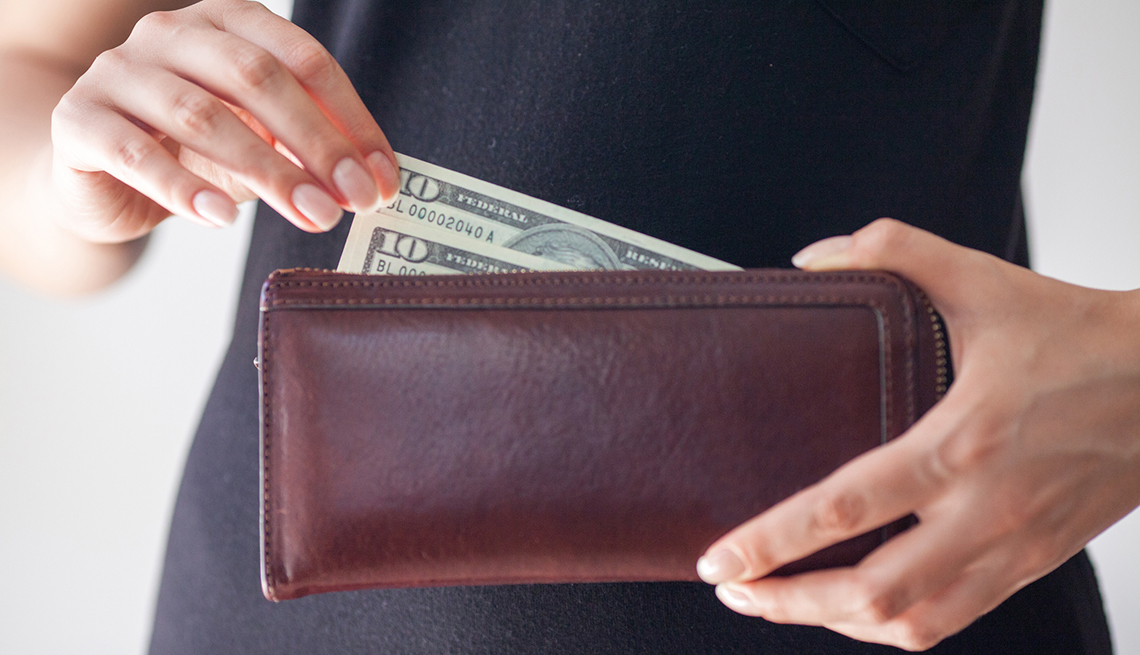 a woman taking a ten dollar bill from her wallet