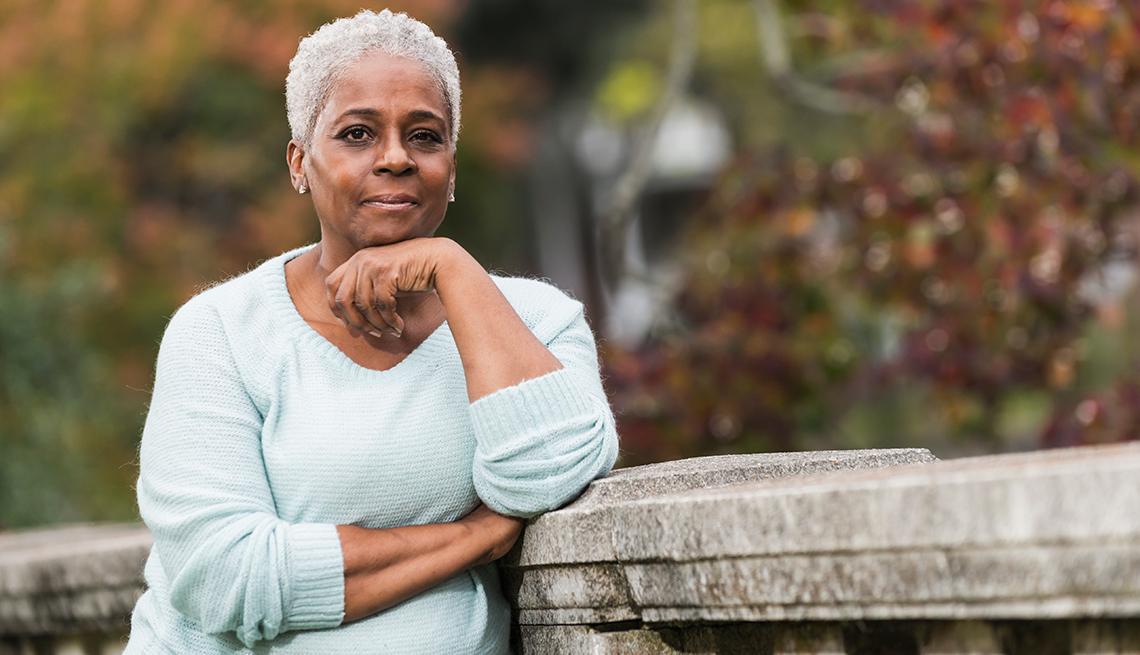 Mature African-American woman, outdoors, stone railing, AARP Foundation, Find Help, Local Assistance Directory