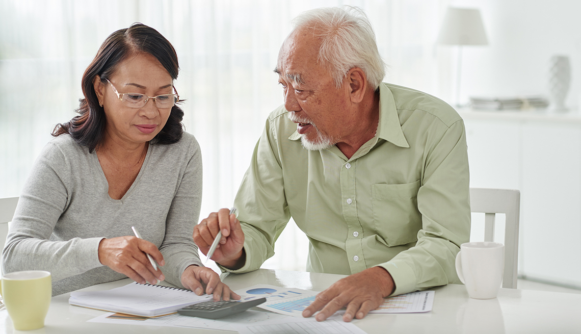 Senior Asian business couple discussing financial documents, Finances 50 plus, AARP Foundation