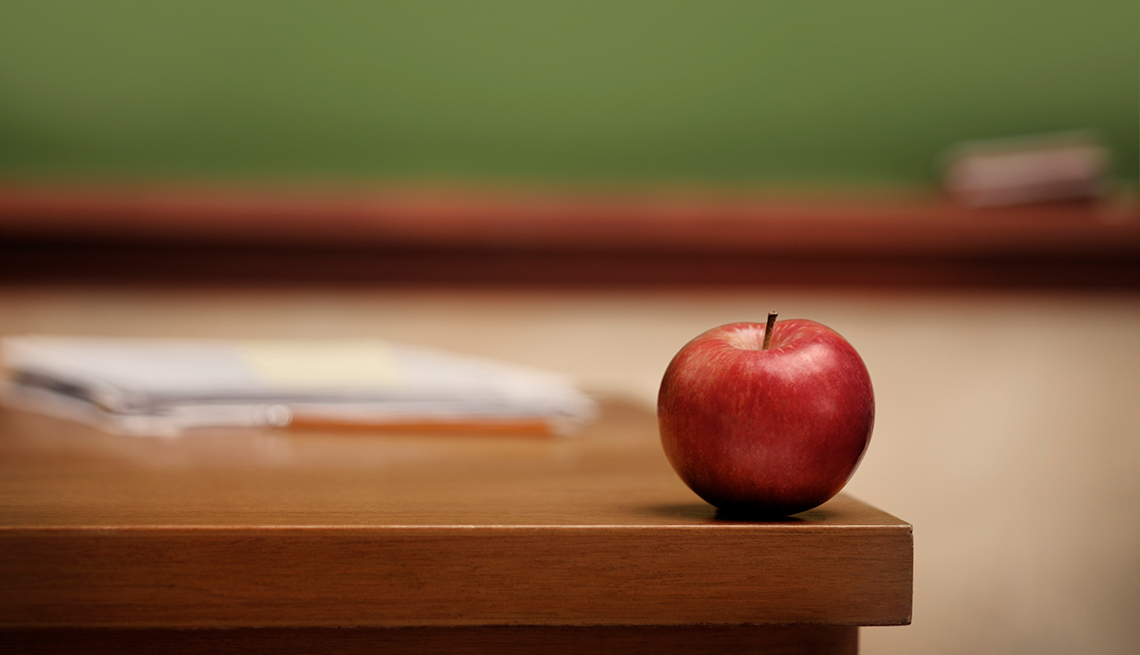 Apple on classroom desk, blackboard, Take a class, Finances 50 plus, AARP Foundation