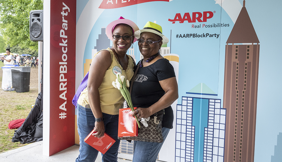 two women posing in an A A R P booth at the dogwood festival