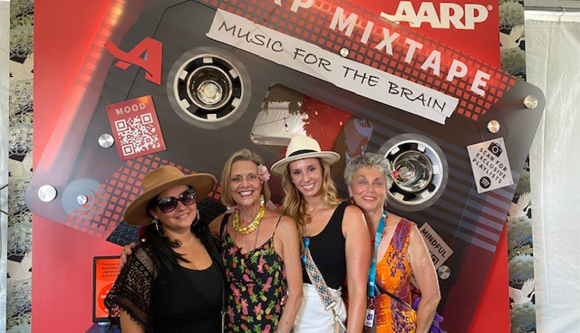 four women standing in front of an a a r p poster