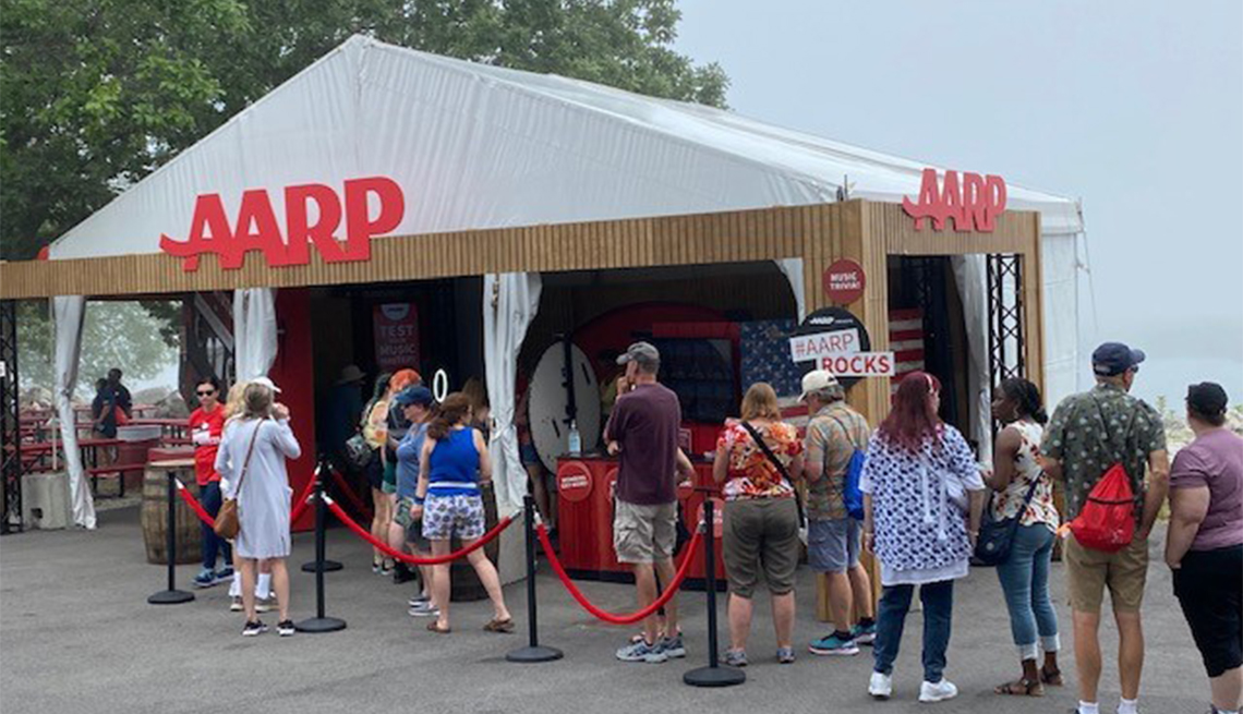 A line of people standing outside of an a a r p event tent
