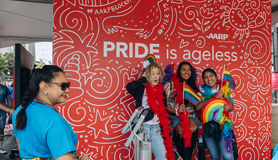 three people posing in front of an a a r p pride is ageless sign
