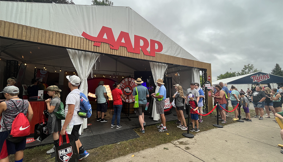 a group of people in line outside an A A R P tent at the minnesota state fair