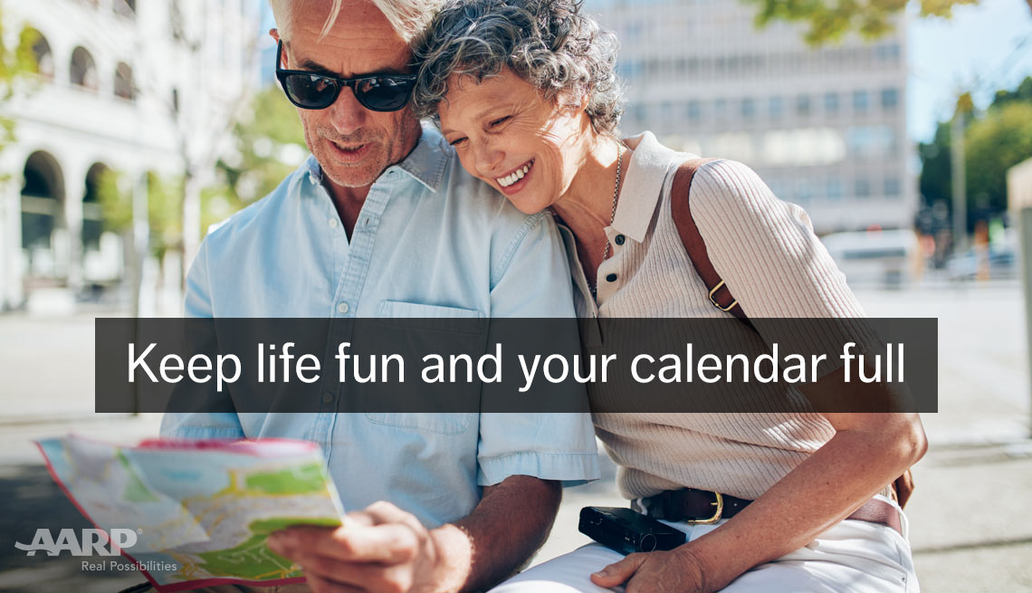 A middle aged caucasian couple look at a map outdoors with text that reads keep life fun and your calendar full.