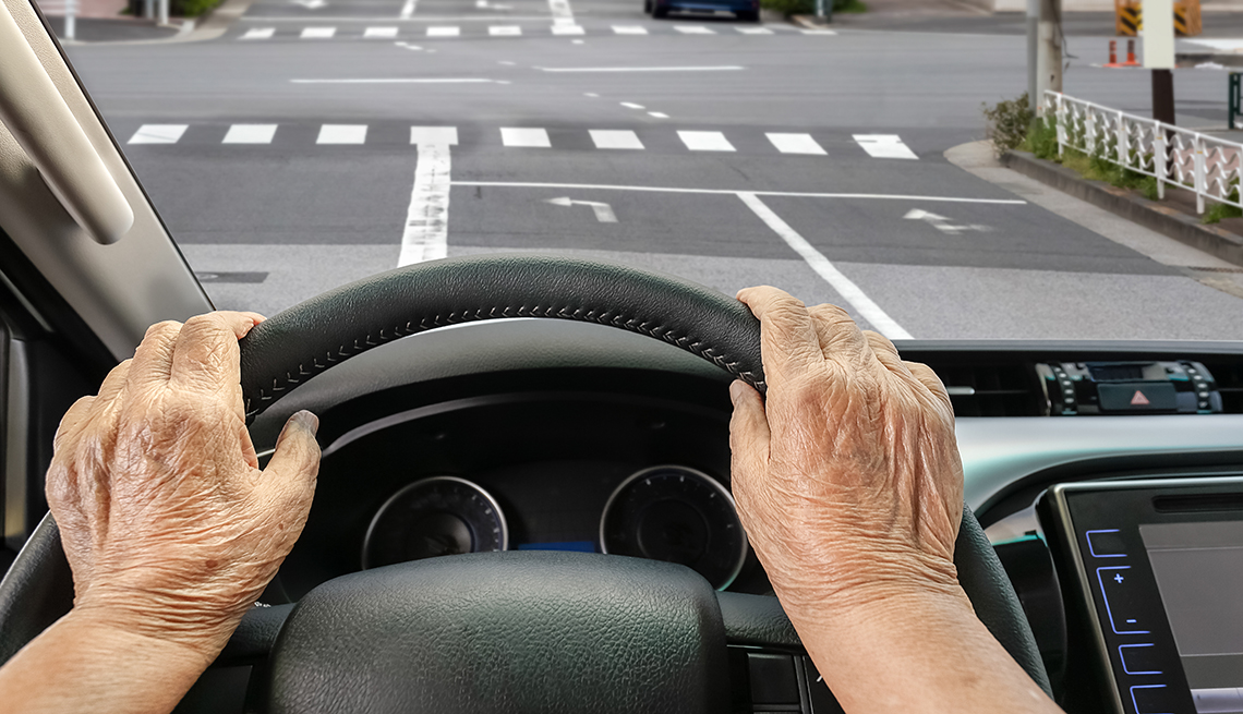 older woman driving on a city street