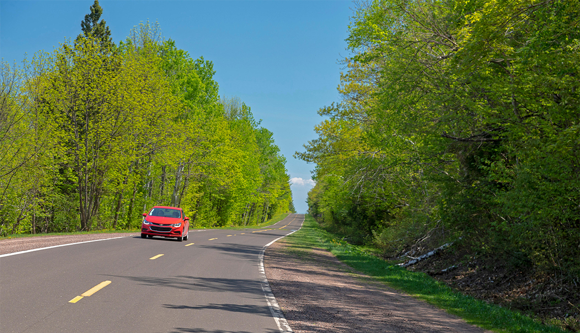 red car on Highway 107 in Porcupine Mountains Wilderness State Park