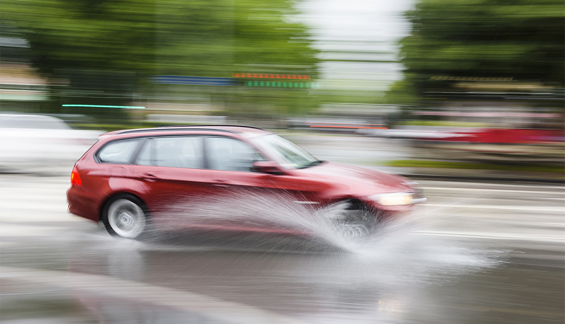 red car on wet pavement