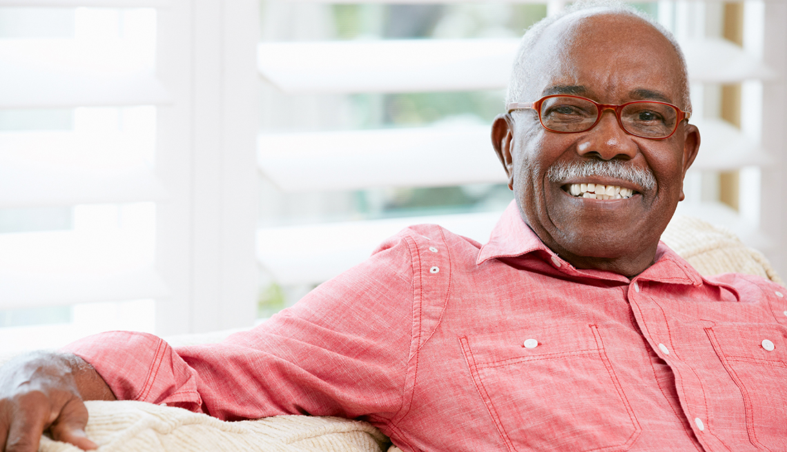 Smiling, mature African American man sitting in front of window