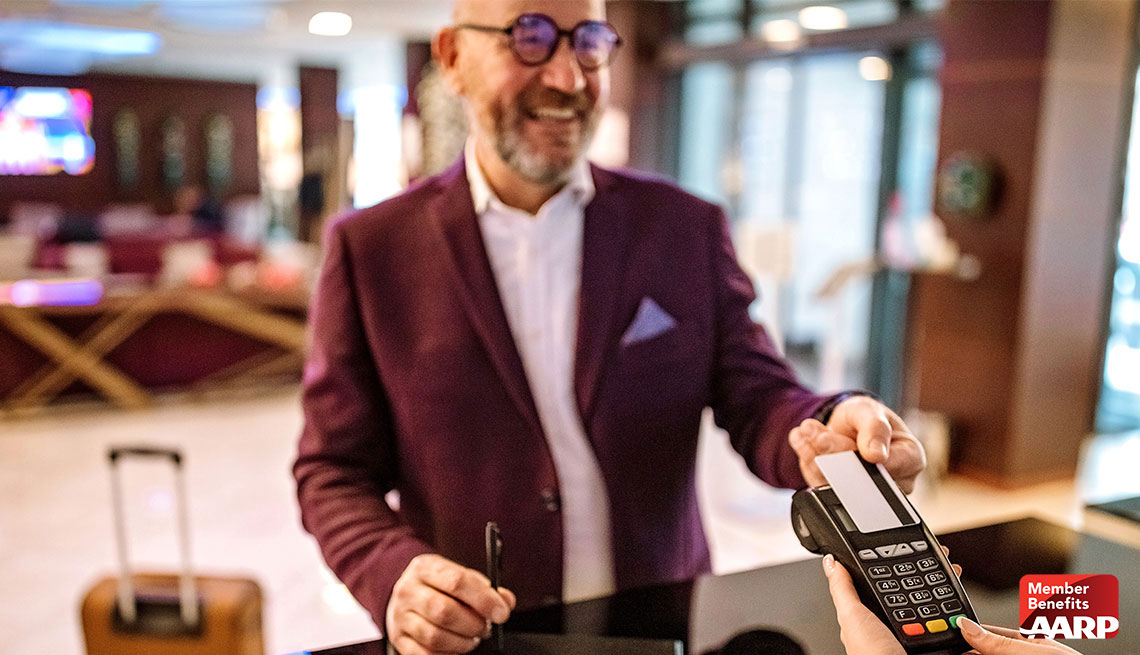 man in glasses checking in hotel with credit card