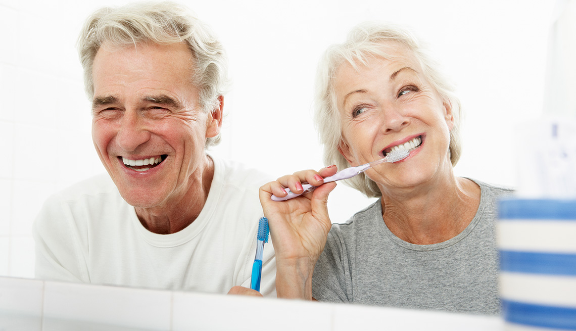 Senior Couple In Bathroom Brushing Teeth, Dental Insurance