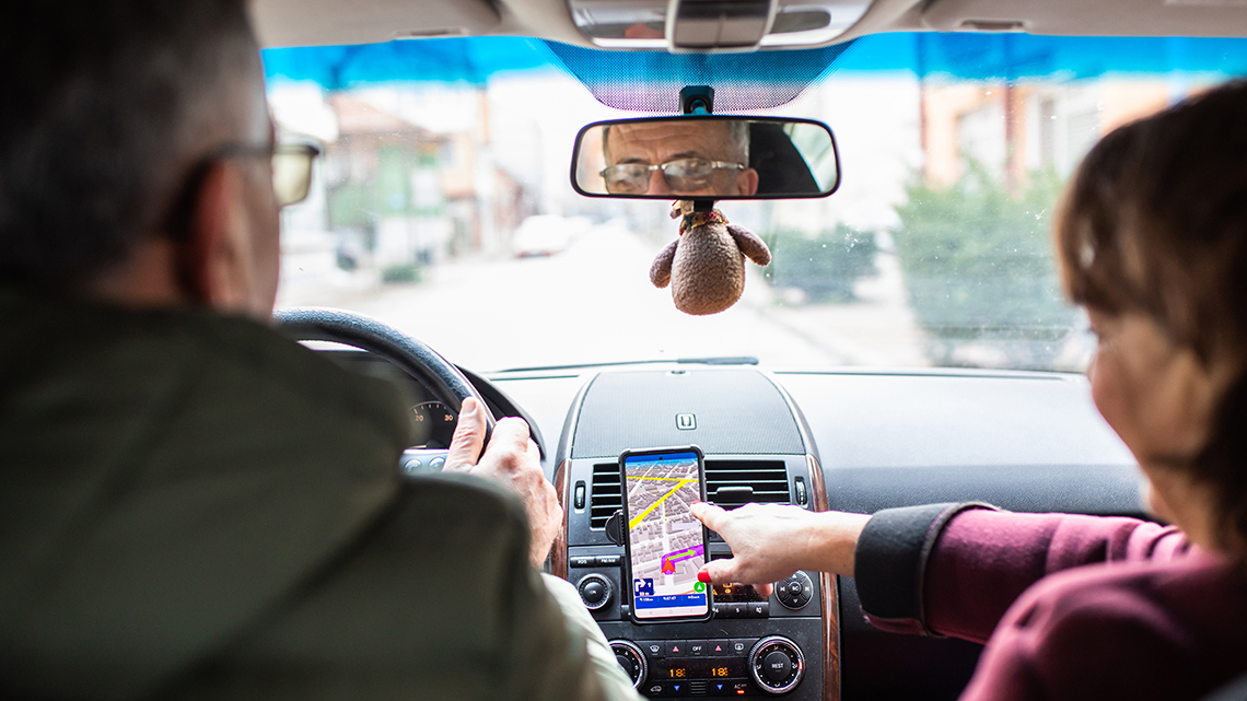 A mature couple are using a map app while driving