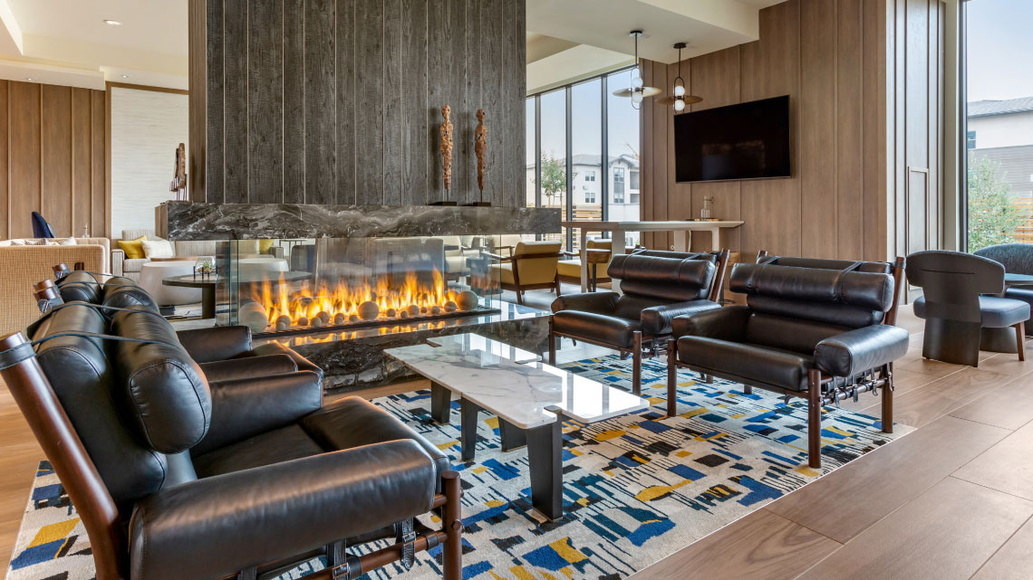 hotel lobby with fireplace, leather furniture, colorful blue and yellow rug