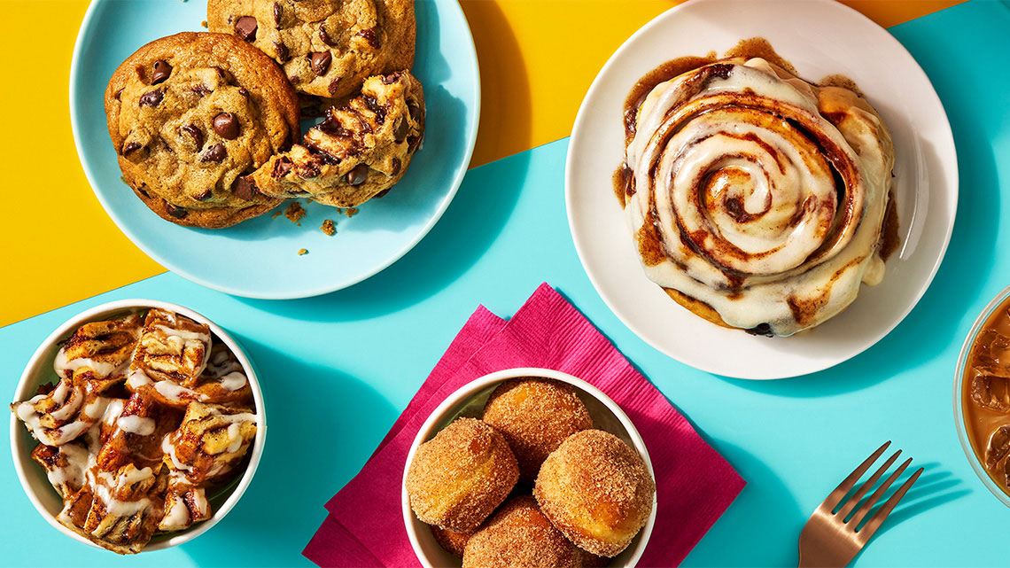 chocolate chip cooks, cinnamon roll bites, donut holes, cinnamon roll whole on a plate