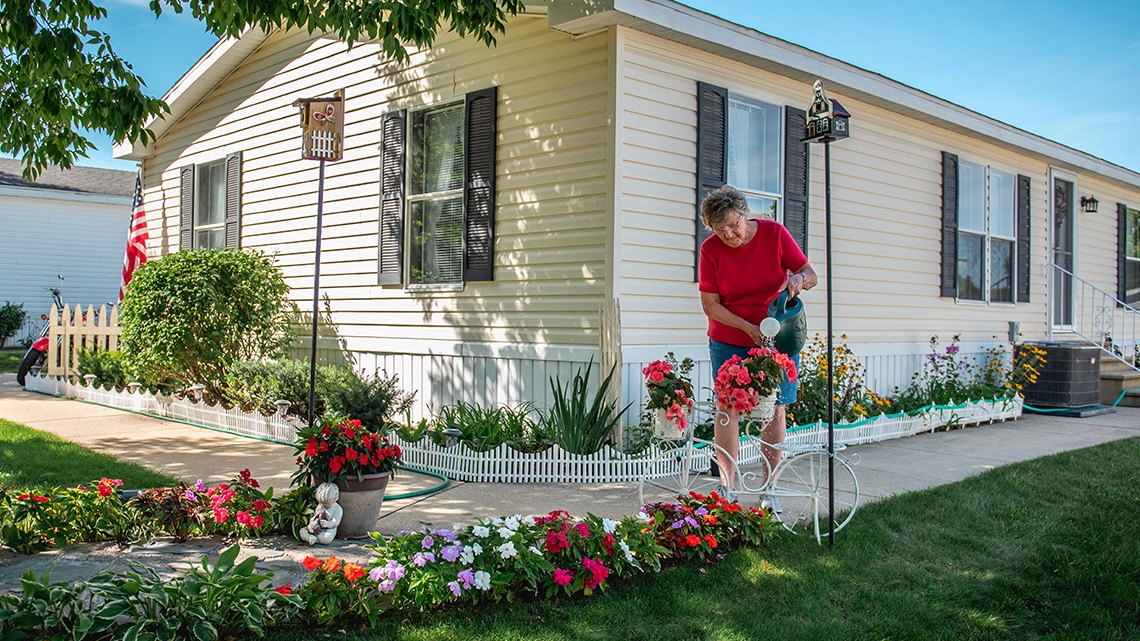 Woman watering flowers mobile home