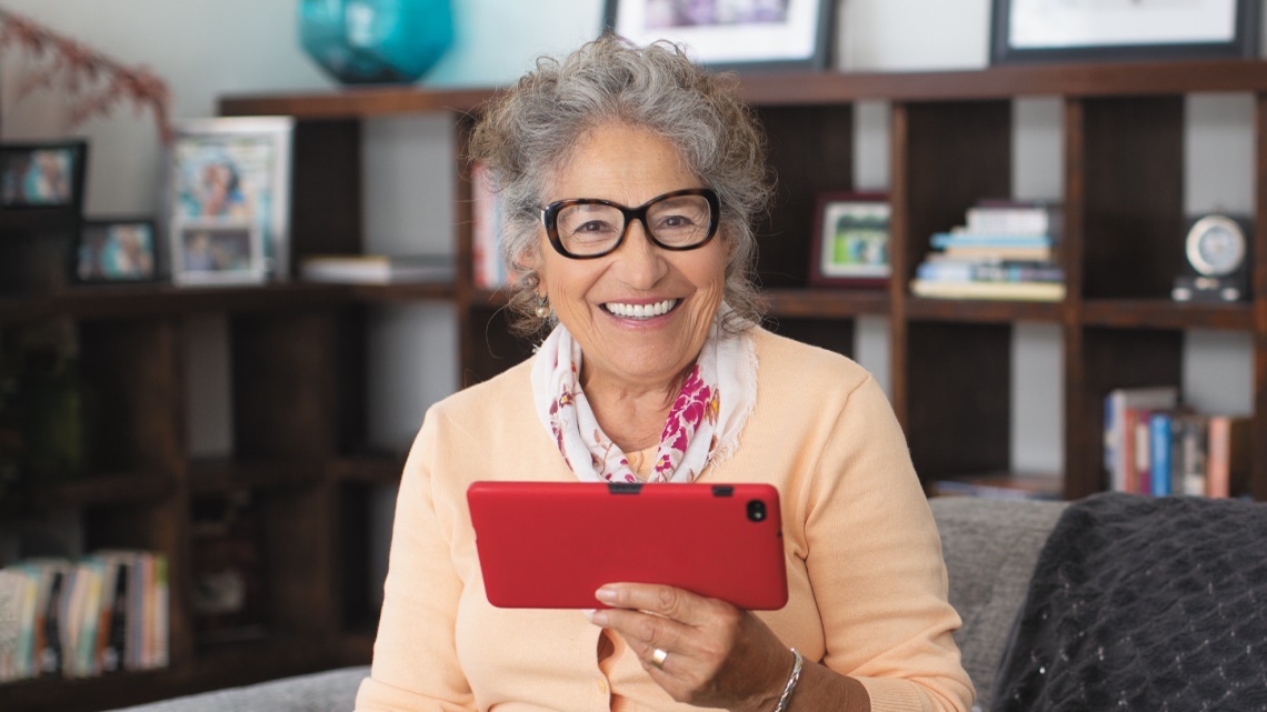 Smiling senior woman, red tablet