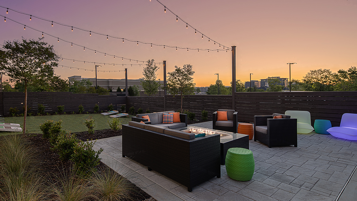 lush outdoor seating area on a hotel patio at sunset