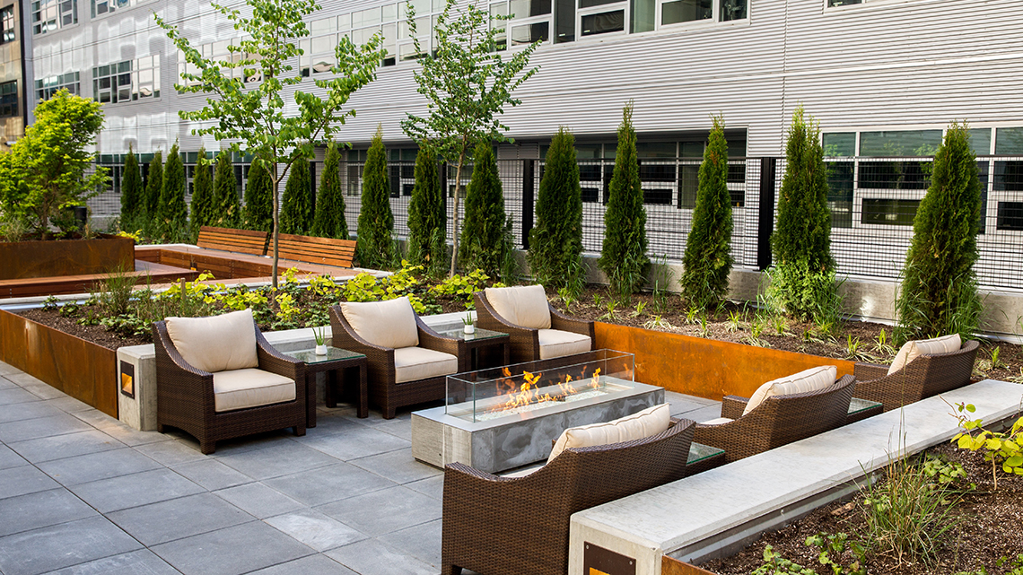upscale outdoor hotel patio seating area with couches and firepit