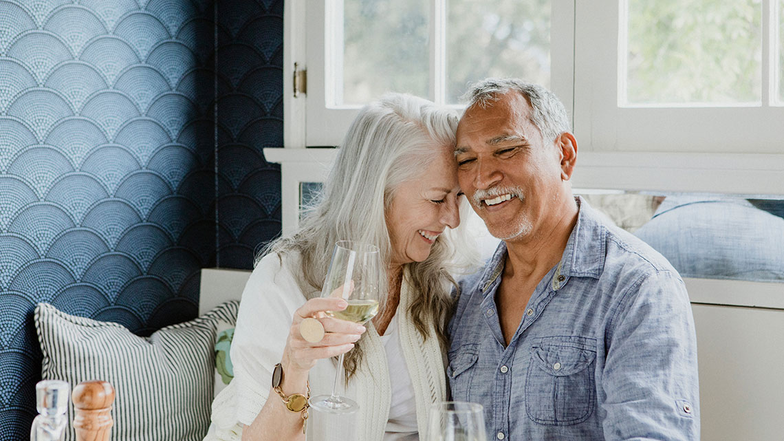 Elderly couple having a white wine