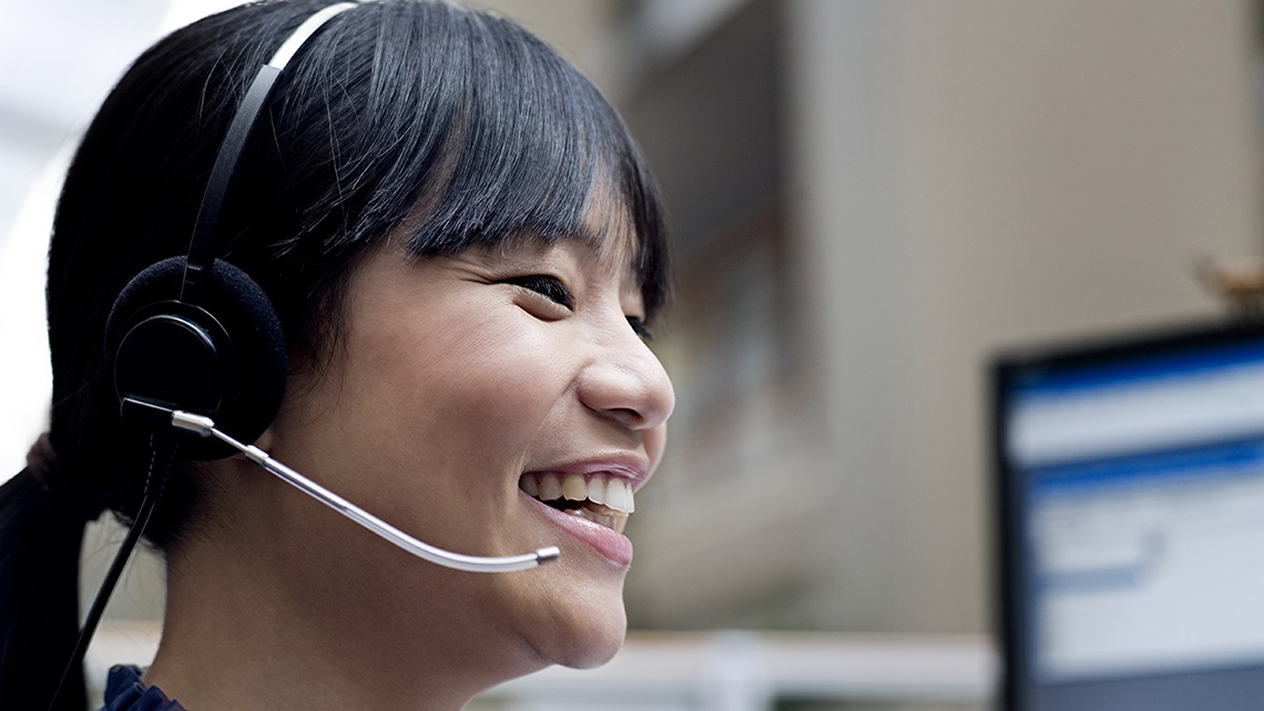 smiling Asian woman wearing headset