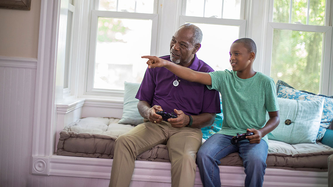Un abuelo jueva videojuegos con su nieto.