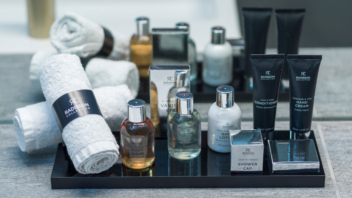 toiletries at a hotel with towels, lotions, hair care and more