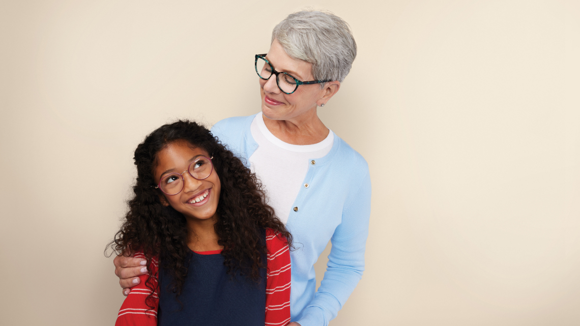 woman looking at girl smiling with both wearing glasses