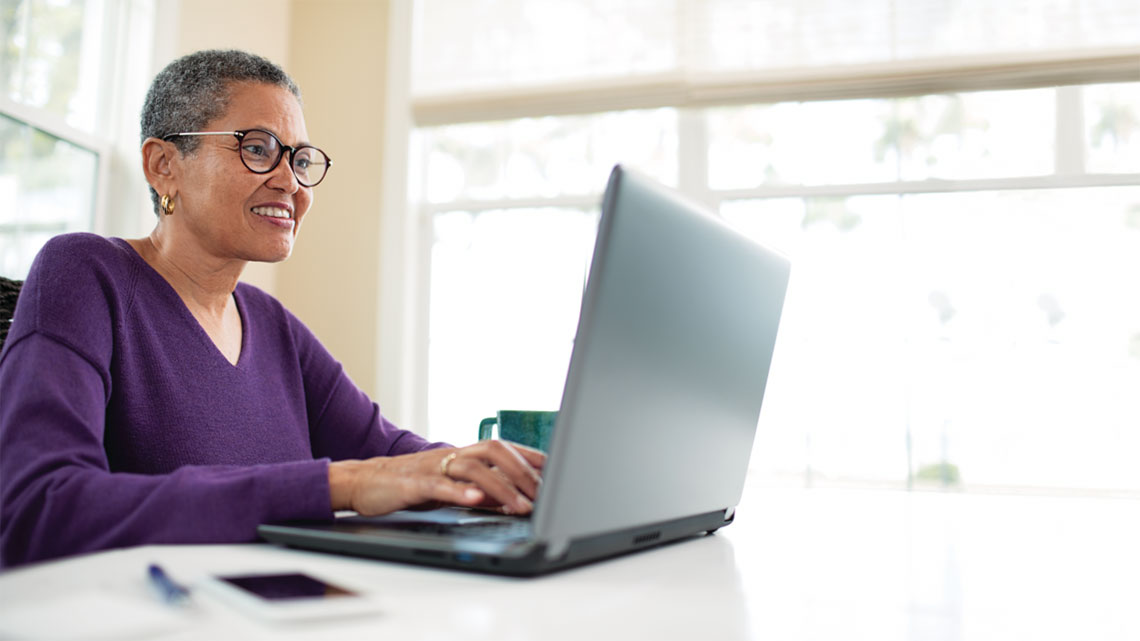 medicare advantage african american woman at desk typing on laptop