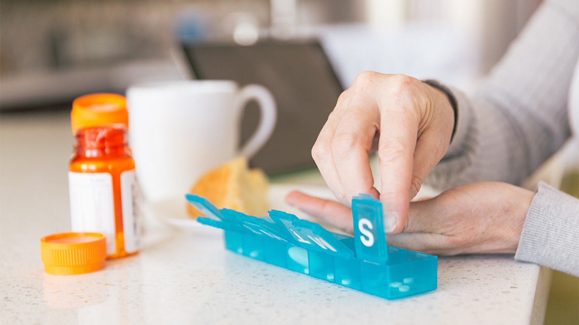 woman hands pill bottle weekly sorter