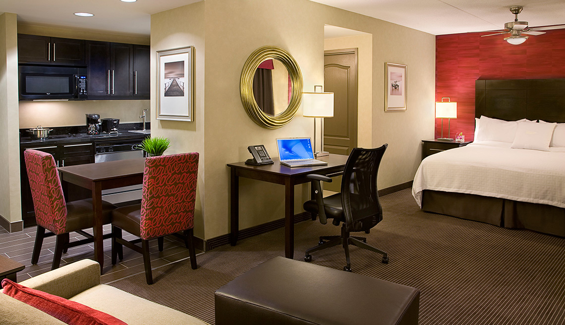 Una habitación suite del hotel Hilton con mesa, silla, cama, cocina y mesa