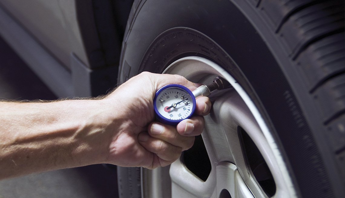 Person checking tire air pressure