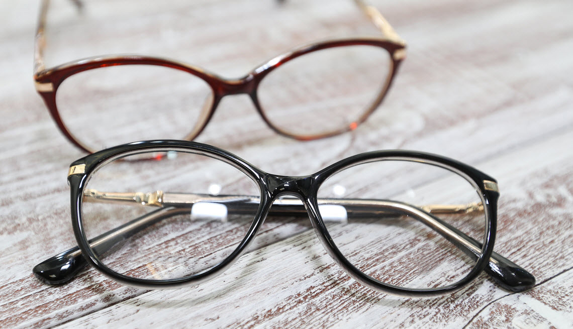 Set of two eye glasses laying on a table