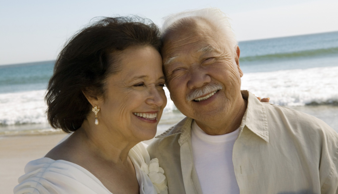 Couple smiling while standing on a beach
