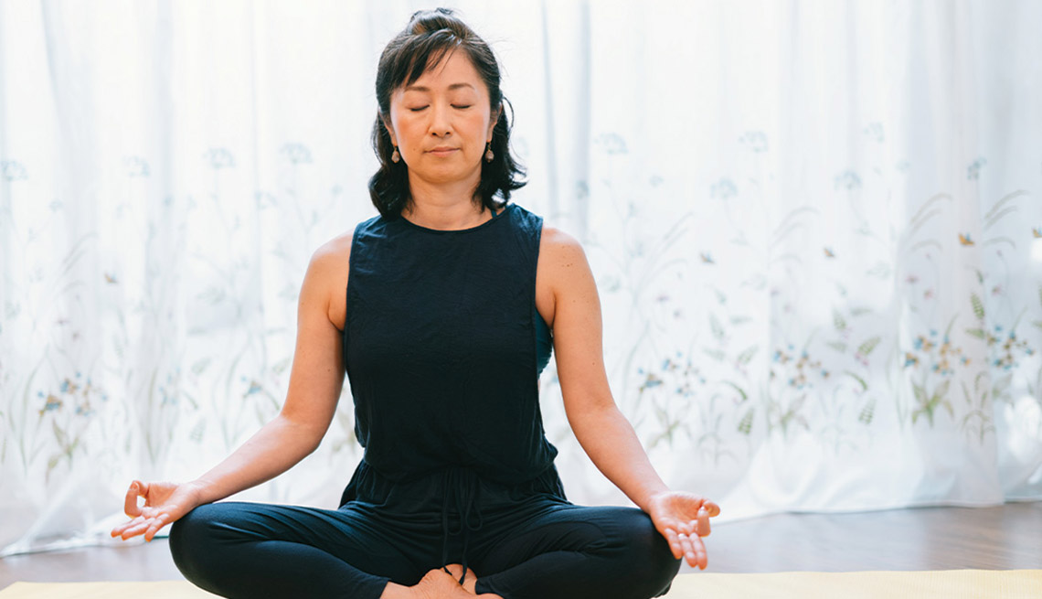 a woman sitting with her legs crossed meditating