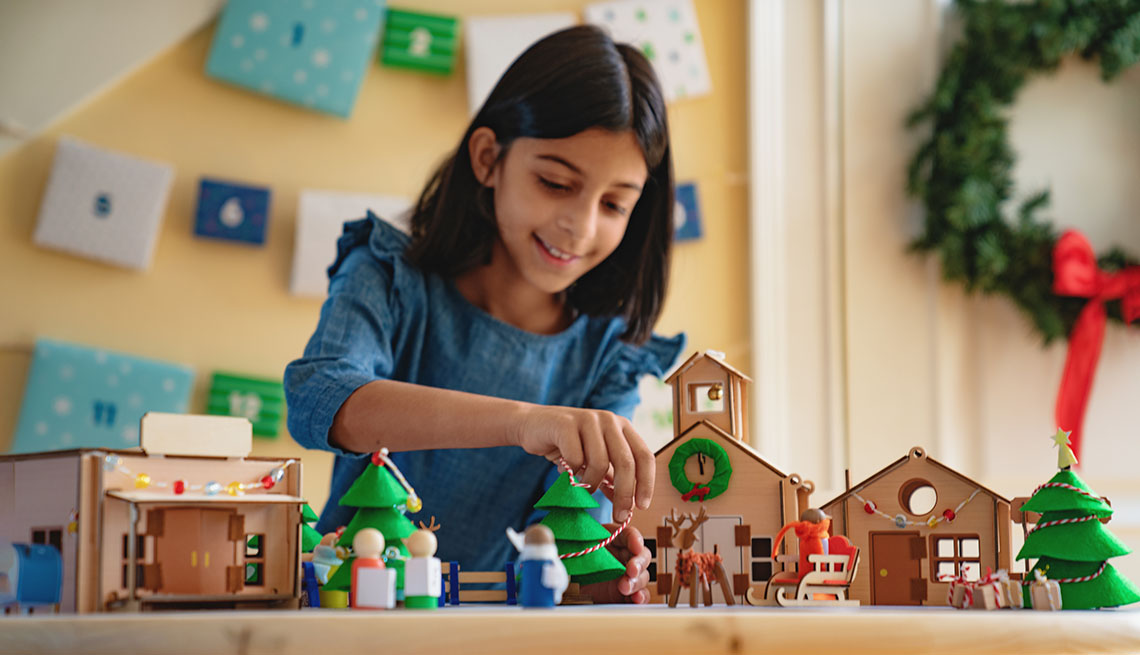 A young girl building a christmas village