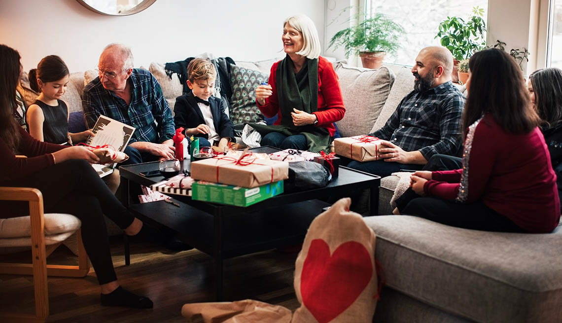a large family sitting together on a couch opening christmas presents