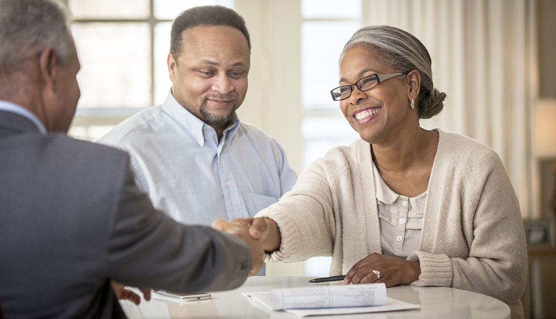 African American couple shaking hands with businessman
