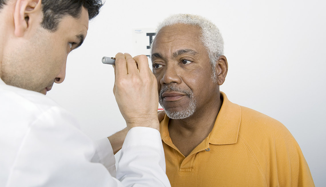 Doctor examines senior man's eyesight