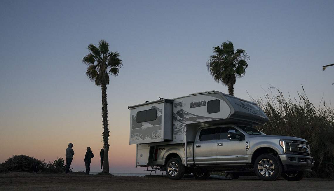 An RV at dusk with Palm trees