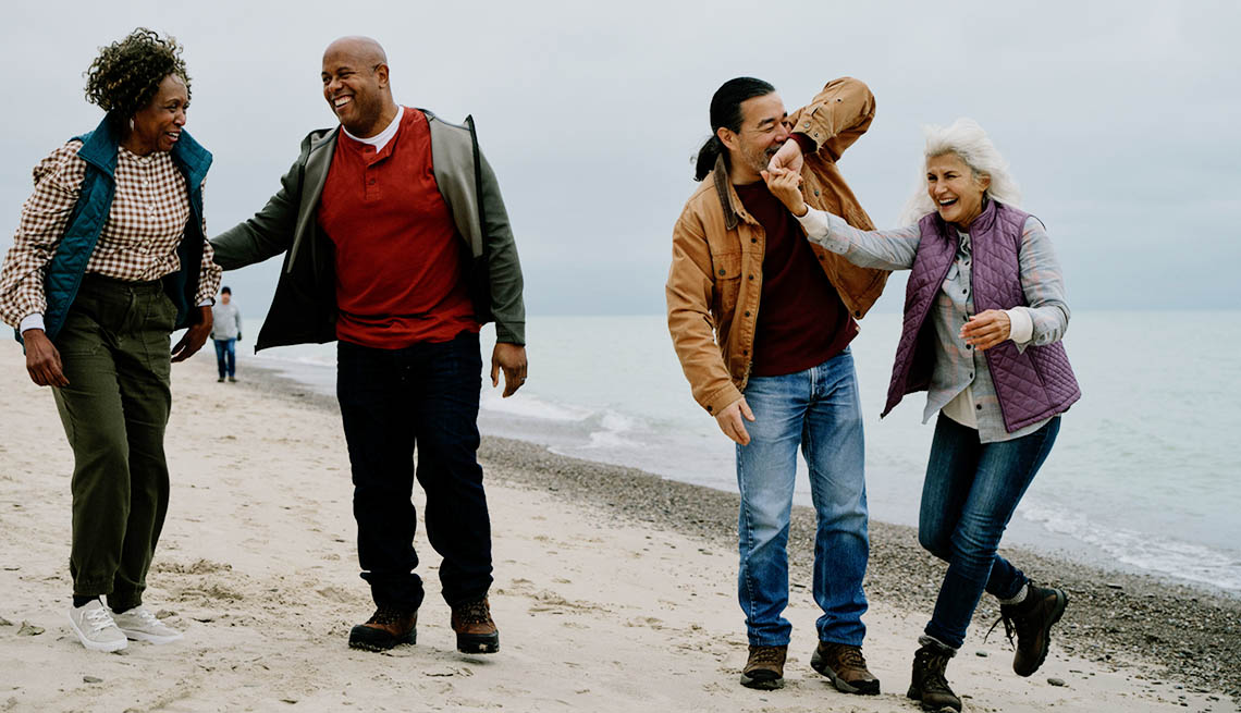 Two older couples walking on the beach