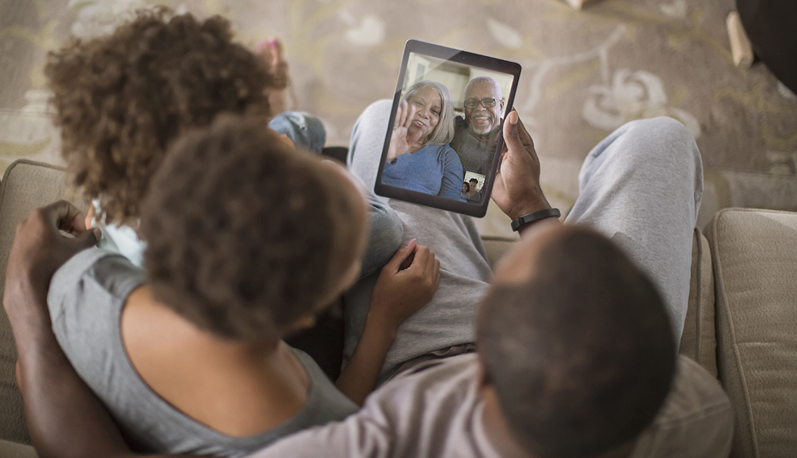 A family having a video call with their older parents