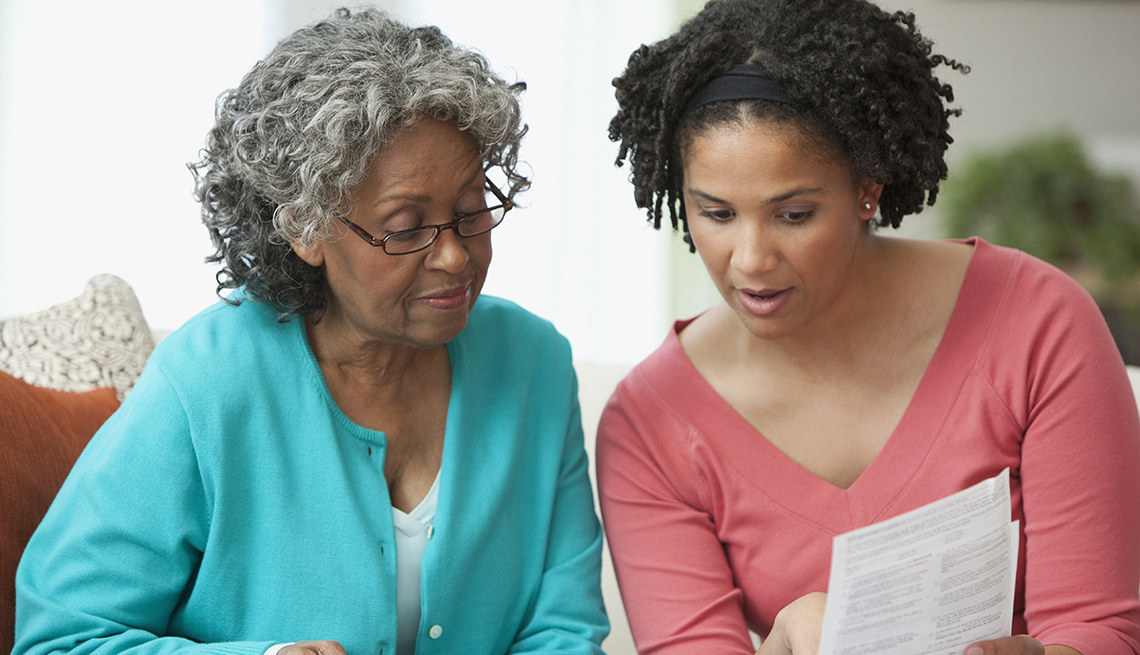 A mother and daughter discussing financial paperwork together