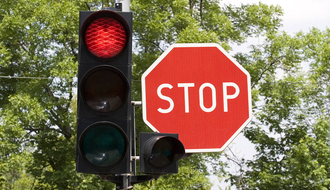 A red traffic light and a red stop sign next to each other