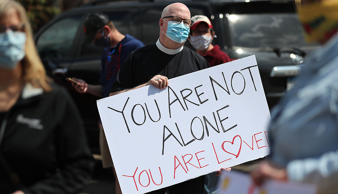 Un hombre sostiene un cartel que dice no estás solo, alguien te ama