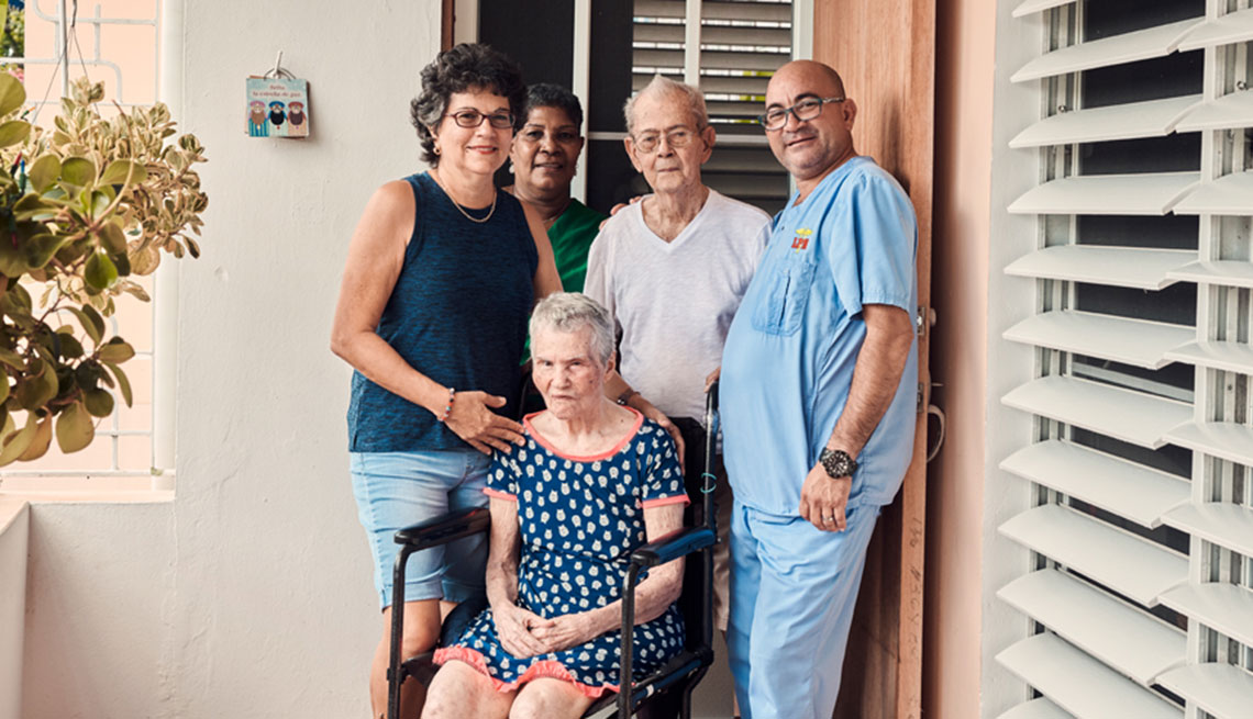 Mireya Pérez del Rio posa junto a sus padres en su hogar en Guaynabo, Puerto Rico, y con dos asistentes