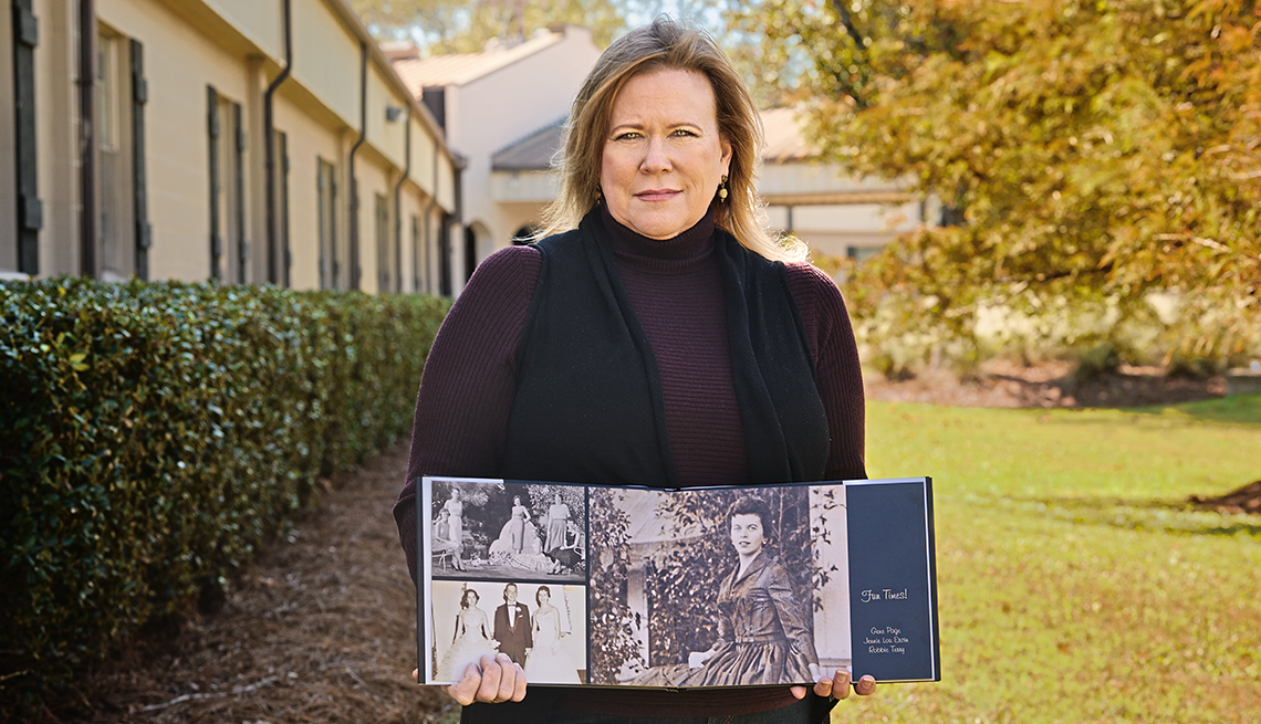 alison lolley holds open a photo scrapbook that contains pictures of her mother