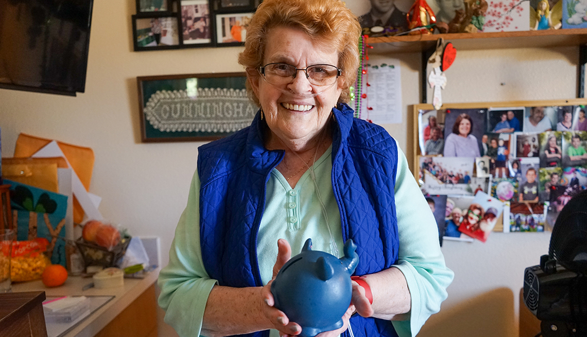 nursing home resident alice cunningham holding a piggy bank