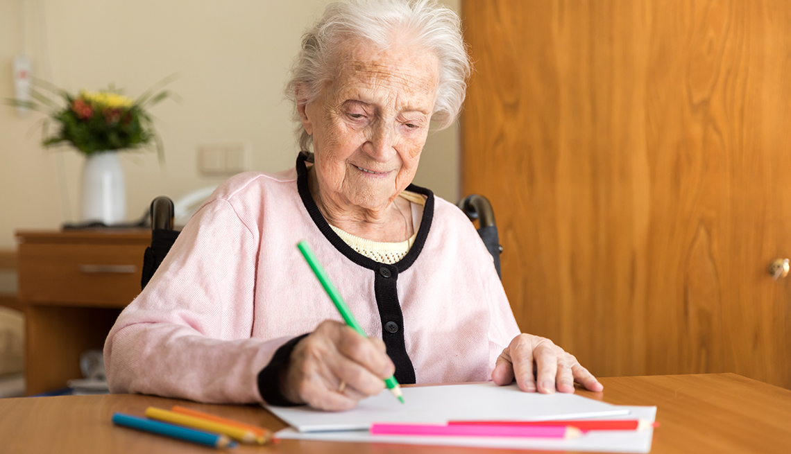 A woman with dementia drawing with colored pencils