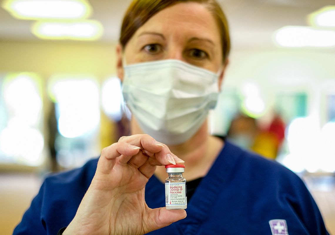 Una enfermera sostiene un vial de vacuna.